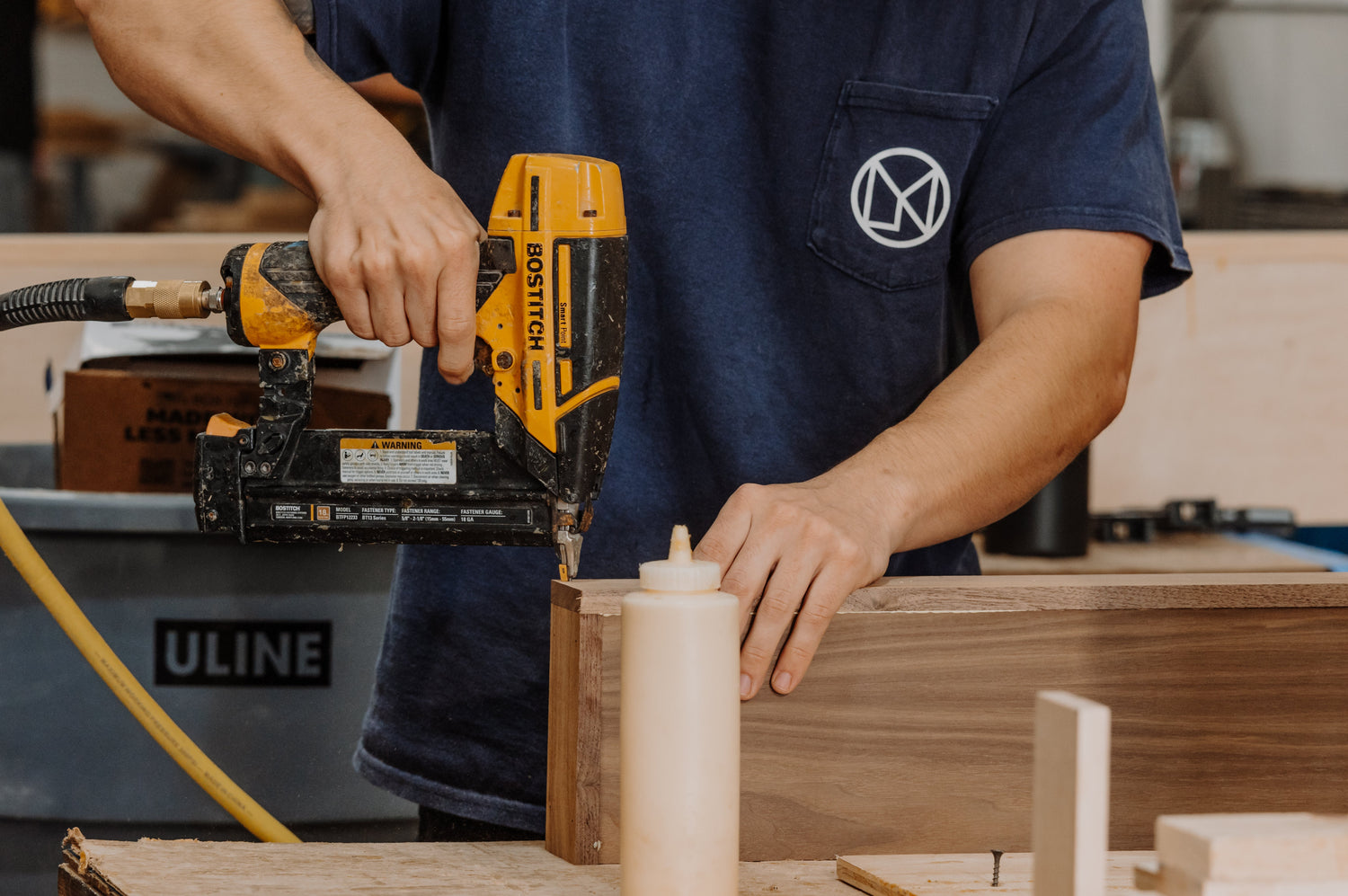 man using nail gun to assemble floating shelf